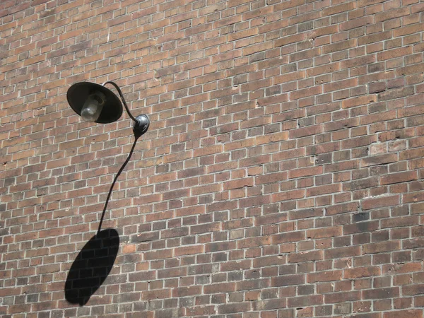 Lamp with shadow on brick wall Royalty Free Stock Images