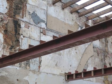 Duvarları dik tutmak için iki ev arasındaki metal çubuk ya da kiriş.