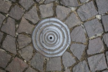 Viterbo İtalya 'da bir caddede demir rögar kapağı.