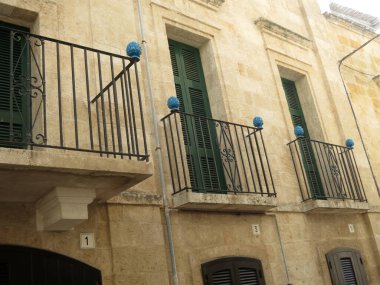 Polignano sokaklarında üç mavi balkon.