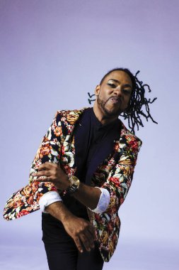 Çiçek desenli bir takım elbise giyen bir adamın stüdyo portresi.