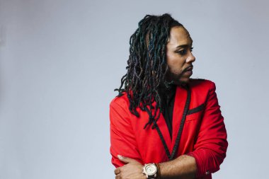 Kapalı stüdyo portresi. Kırmızı ceketli ve rastalı bir adam.