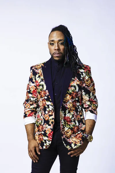 Retrato de estudio de un hombre con un traje con estampado de flores y rastas — Foto de Stock