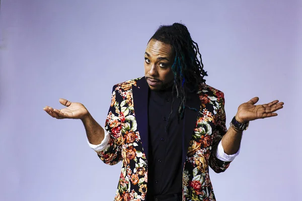 Retrato de estudio de un hombre con un traje con estampado de flores y rastas — Foto de Stock