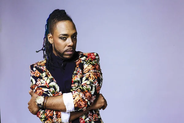 Estúdio retrato de um homem vestindo uma flor estampado terno e dreadlocks — Fotografia de Stock