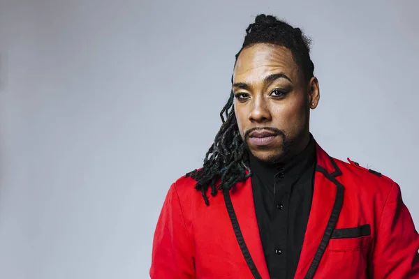 Retrato de estudio de un hombre con un traje de chaqueta roja y rastas — Foto de Stock