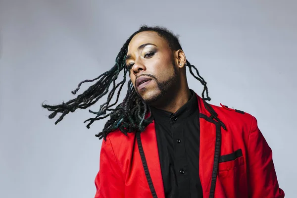 Closeup studio retrato de um homem vestindo um terno casaco vermelho e dreadlocks — Fotografia de Stock