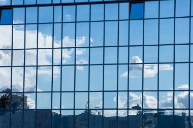 Doku, şekil, arka plan. Pencere yapımında yansıma. Mavi pencereler, pencerelere yansıyan bulutlar