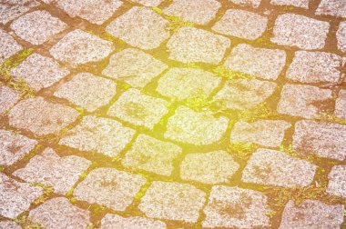 doku, arka plan. Granit taş kaldırım. Asfalt karayolu sokak. herhangi bir taş döşeli alan veya yüzey. Eski Arnavut kaldırımlı yol kaldırım doku, çim taşları arasında