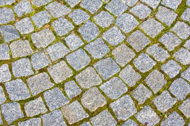 doku, arka plan. Granit taş kaldırım. Asfalt karayolu sokak. herhangi bir taş döşeli alan veya yüzey. Eski Arnavut kaldırımlı yol kaldırım doku, çim taşları arasında