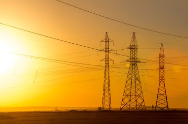 Yüksek gerilim enerji nakil hattı. Enerji ayağı. Gün batımında,