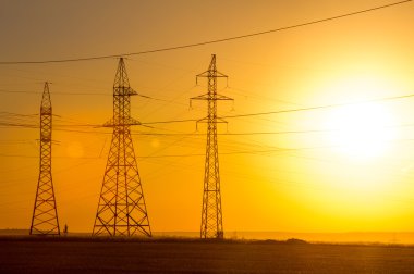 Yüksek gerilim enerji nakil hattı. Enerji ayağı. Gün batımı, şafakta. Elektrik