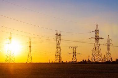 Yüksek gerilim enerji nakil hattı. Enerji ayağı. Gün batımında,