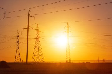 Yüksek gerilim enerji nakil hattı. Enerji ayağı. Gün batımı, şafakta. Elektrik