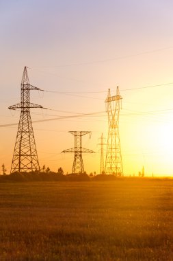 Yüksek gerilim enerji nakil hattı. Enerji ayağı. Gün batımı, şafakta. Elektrik