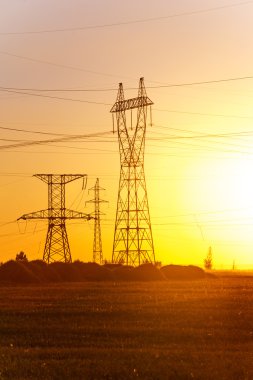 Yüksek gerilim enerji nakil hattı. Enerji ayağı. Gün batımı, şafakta. Elektrik