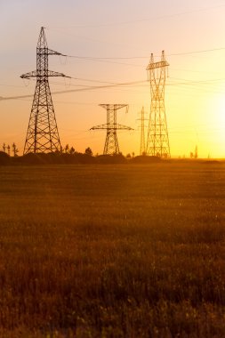 Yüksek gerilim enerji nakil hattı. Enerji ayağı. Gün batımı, şafakta. Elektrik