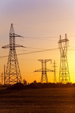 Yüksek gerilim enerji nakil hattı. Enerji ayağı. Gün batımı, şafakta. Elektrik