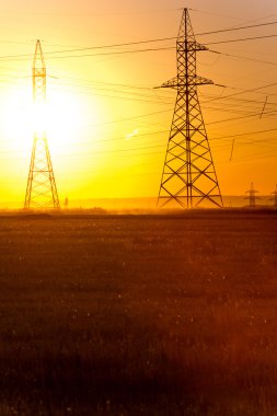 Yüksek gerilim enerji nakil hattı. Enerji ayağı. Gün batımı, şafakta. Elektrik