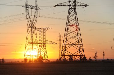 Yüksek gerilim enerji nakil hattı. Enerji ayağı. Gün batımında,