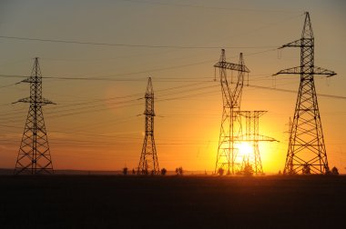 Yüksek gerilim enerji nakil hattı. Enerji ayağı. Gün batımı, şafakta. Elektrik