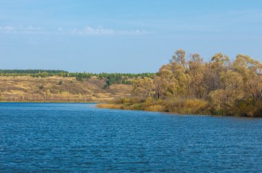 Fall river. Göl ile güzel ormanda kırmızı ve sarı renk üzerine sonbahar renkli yeşillik. Bir nehir, sonbahar yatay. Güzel bir sonbahar sahne, sonbahar