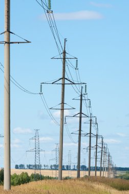 Elektrik pilon mavi gökyüzü karşı detay: yüksek gerilim elektrik direği aşağıdan