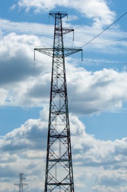 Elektrik pilon mavi gökyüzü karşı detay: yüksek gerilim elektrik direği aşağıdan