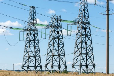 Elektrik pilon mavi gökyüzü karşı detay: yüksek gerilim elektrik direği aşağıdan