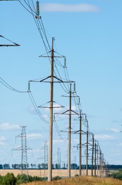 Elektrik pilon mavi gökyüzü karşı detay: yüksek gerilim elektrik direği aşağıdan