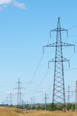 Elektrik pilon mavi gökyüzü karşı detay: yüksek gerilim elektrik direği aşağıdan