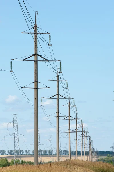 Elektrik pilon mavi gökyüzü karşı detay: yüksek gerilim elektrik direği aşağıdan