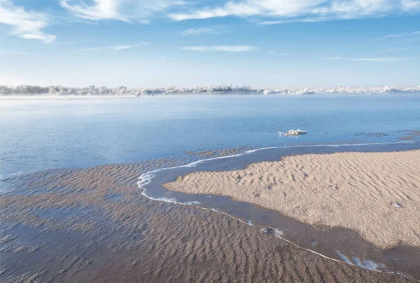 Winter landscape. The water in the river mist from the cold. sand beach is covered with ice. Ili River in the winter. Kazakhstan