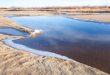 Kış manzarası. Nehir sis soğuk suda. kum plaj buzla kaplıdır. Ili Nehri kış. Kazakistan