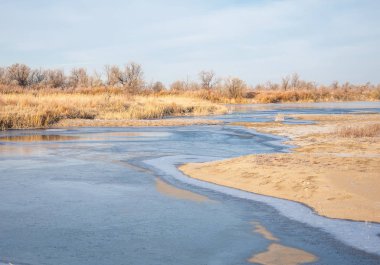 Kış manzarası. Nehir sis soğuk suda. kum plaj buzla kaplıdır. Ili Nehri kış. Kazakistan
