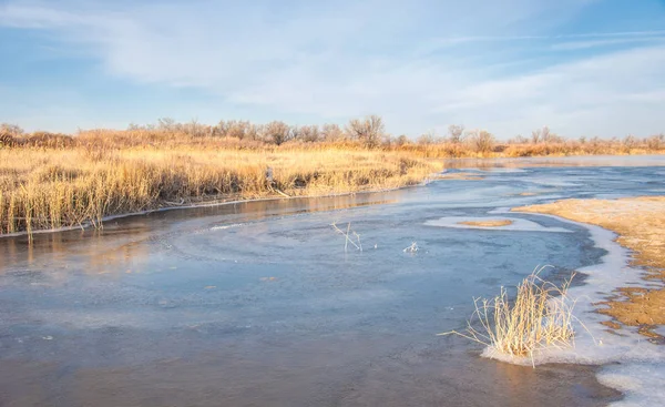 Winter landscape. The water in the river mist from the cold. sand beach is covered with ice. Ili River in the winter. Kazakhstan