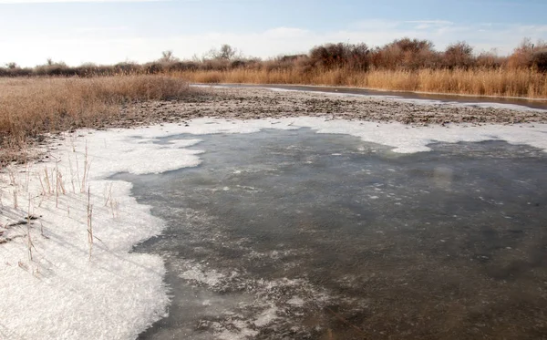 Winter landscape. The water in the river mist from the cold. sand beach is covered with ice. Ili River in the winter. Kazakhstan