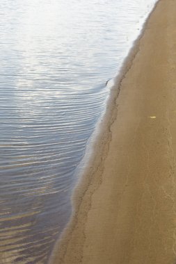 Doku, arka plan. kum plaj. gevşek taneli madde, soluk sarımsı kahverengi, silisli ve diğer kayalar erozyon kaynaklanan ve plajları büyük bir kurucu şekillendirme,