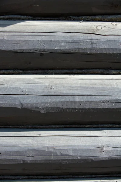 Texture, background. The house is assembled from wooden logs. A log house made of pine, cedar, larch. Logs wooden house painted black.