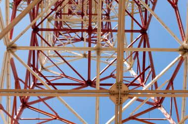 Doku enerji ayağı. Elektrik pilon mavi gökyüzü karşı detay: yüksek gerilim elektrik direği aşağıdan