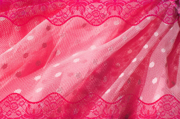 The texture of fabric lace with sequins on fabric background. a small, shiny disk sewn as one of many onto clothing for decoration. Magenta, Hot pink, Cerise