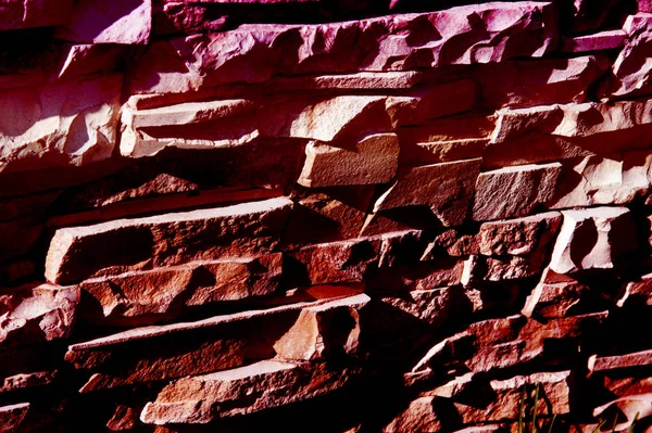 Texture, background, pattern. Natural stone lined wall. Hard rock chunks or solid mass, as well as a piece, vertical part of the building premises.