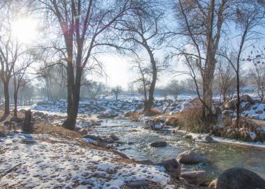 su küçük bir nehir erken ilkbahar akarsu. Bahar sahne. donmuş bir dere ile dağ manzarası