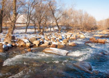 su küçük bir nehir erken ilkbahar akarsu. Bahar sahne. donmuş bir dere ile dağ manzarası