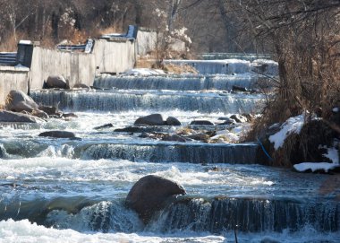 su küçük bir nehir erken ilkbahar akarsu. Bahar sahne. donmuş bir dere ile dağ manzarası