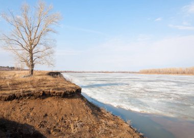 Bahar River, buz Nehri üzerinde. çıplak ağaçlar ve mavi gökyüzünde güzel bulutlar güzel bahar manzara nehir buz ile erimiş