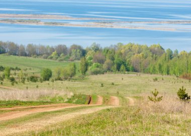 Bahar, büyük bir nehir, renkli ağaçlar.