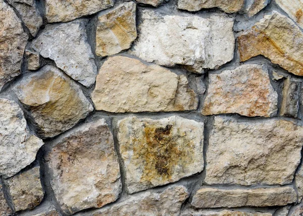 Текстура, фон. Забор, облицованный диким камнем, гранитом, песками — стоковое фото