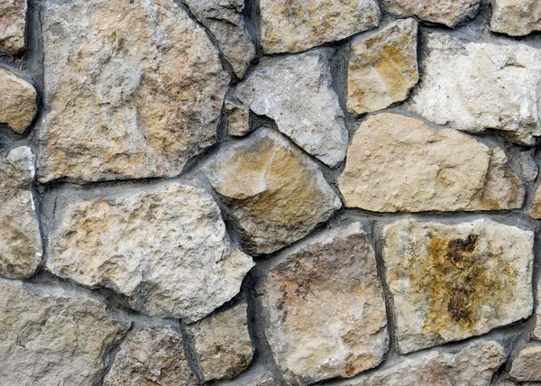 Texture, background. Fence lined with wild stone, granite, sands Stock Image