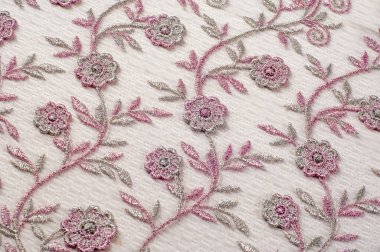Doku, arka plan, desen. Pembe dantel çiçek üzerinde beyaz bir arka plan ile dekore edilmiştir. Arka planını çiçekler ile dekore edilmiş pembe dantel kumaş